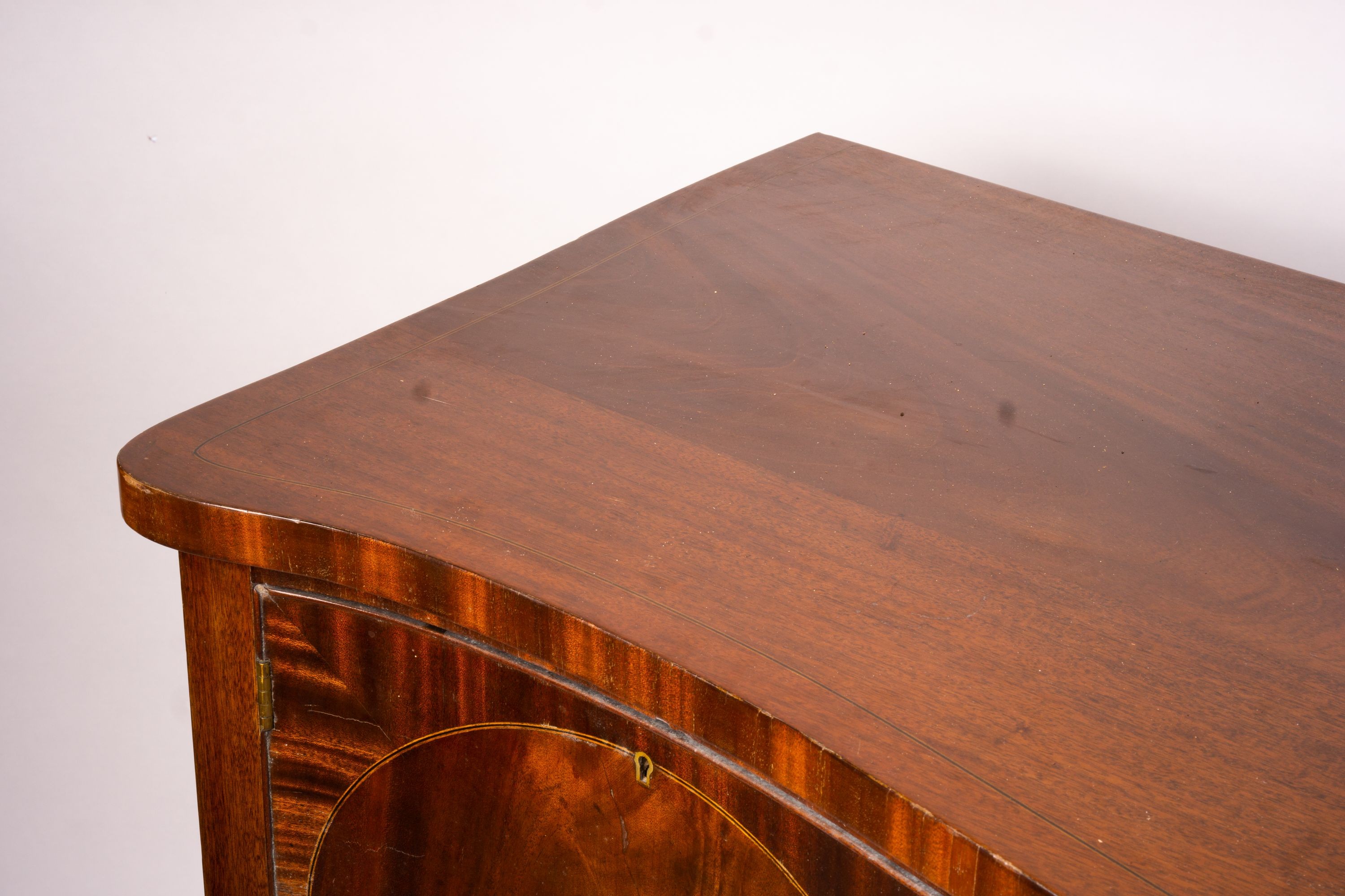 A George III style mahogany serpentine sideboard on square tapered legs, width 184cm, depth 63cm, height 93 cm